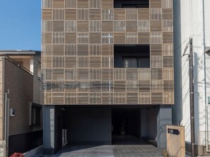 ・ A building featuring a modern latticed outer wall