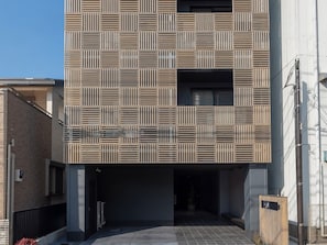 ・ A building featuring a modern latticed outer wall