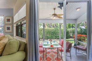 Living room with sliding door to the screened lanai.  Enjoy dinnertime in the great outdoors!