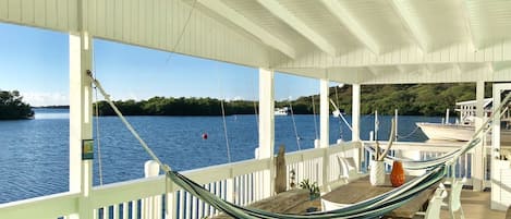 Spacious ocean front balcony with 2 hammocks, dinning table for 10 and seating.