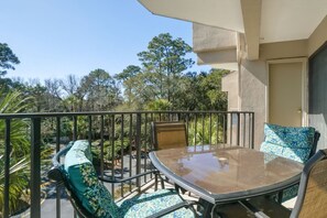 Balcony off of bedrooms & living room with seating and table for 4