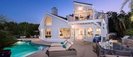 Stunning view of the house from the patio with pool, hot tub, BBQ, and seating