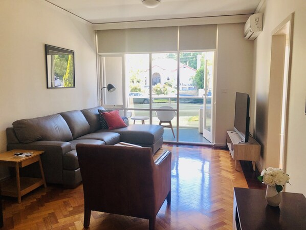 Living room with leather corner lounge, armchair and 55” Smart TV