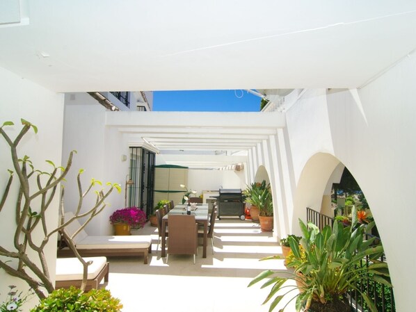 Amplia terraza principal (70m2) mesa de ratán para 10