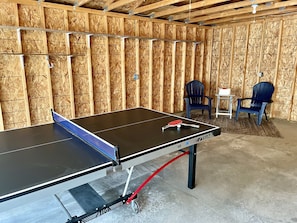 The garage has a ping pong table, seating area, and a dartboard. This space is available from April - October.
