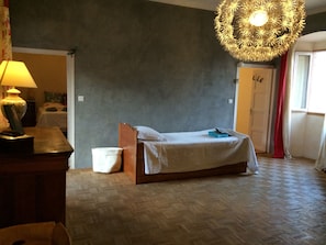 Grande salle donnant accĂšs Ă deux chambres avec lit d'appoint