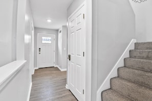 Front entryway with a glimpse of the stairwell that leads to upstairs bedrooms
