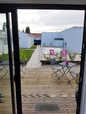 La vue de la terrasse sur la piscine et le jardin