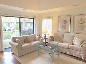 Bright living room with raised ceiling and partial lagoon view