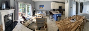 View of living, dining areas & kitchen. Rear patio door on the left