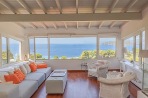 Living room with comfortable sofa and armchairs to relax and enjoy the seaview.