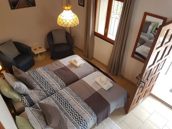 view from mezzanine to the beds and sitting chairs and the door to the terrace