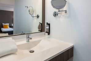 Highlighting thoughtful design, the bathroom sink area combines functionality and style with a sleek countertop, practical storage solutions, and convenient amenities, ensuring a pleasant and efficient space for personal care.