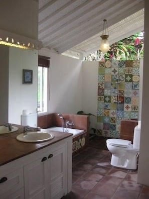 Bathroom with open air shower and garden.  View to the rice paddies and bathtub.