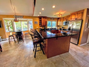 Large breakfast bar with granite countertops that seats 4.