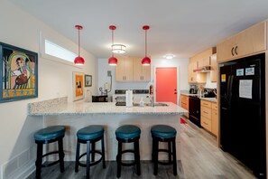 This kitchen is stocked with cookware, small appliances and utensils needed to cook and serve any meal.