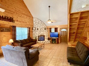 Trails End - Living room has vaulted ceilings, tile floors, rock fireplace and cedar walls.