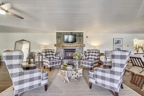 Gas fireplace surrounded by large wing back chairs.