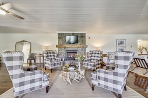 Gas fireplace surrounded by large wing back chairs.