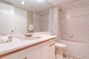 Large bathroom with a bathtub, toilet, sink and extra storage.