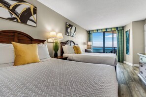Unwind in a bedroom that seamlessly combines coastal charm and modern elegance, with two beds offering a relaxing haven in our oceanfront suite.