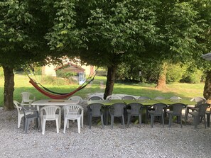 Table ombragée pour 20 personnes devant la maison et à côté du barbecue 