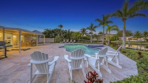 Pool and patio.  Rocking Adirondack chairs with the lanai in view.