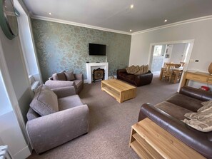 Large living room with leather sofas and two single sofa beds