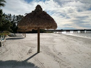 Multiple tikis provide shade or grab beach umbrella from condo.