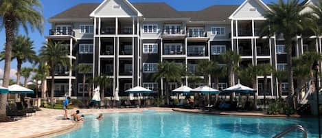 A spacious resort pool flanked by palm trees, offering a refreshing escape.