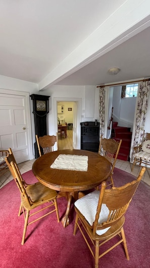 Circular dining room with grandfather clock and view through to kitchen