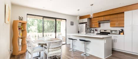 Modern Kitchen fully equipped with stainless steel appliances and stocked with basic cooking essentials.