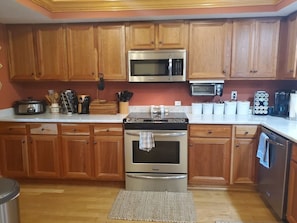 Full kitchen with plenty of cabinet space. Silverware, pots, pans and crockpot.