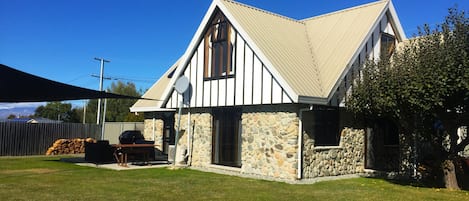 Back garden - fully fenced with BBQ  and seating area on patio under a shade net