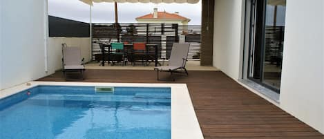 Piscine privée et son espace repas, protégé du soleil, si nécessaire. 