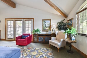 Living room with walk out balcony featuring far off mountain views and overlooking the pool