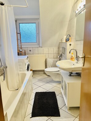 Badezimmer mit Duschwanne und Waschmaschine 