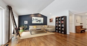 Vaulted ceiling in living room with two sets of sliding doors to the pool.