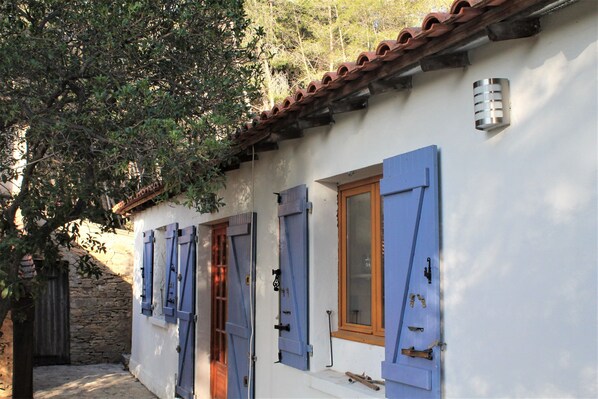 Face sud de la maison avec l'entrée, fenêtre cuisine et fenêtre d'une chambre