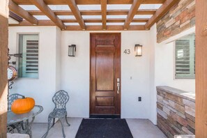Front door, and patio with two seat table 
