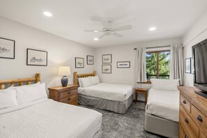 The guest bedroom features two queen beds and one single bed, offering plenty of sleeping space for your group.