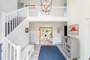 View from the beautiful foyer through living room & sun room to lawn and trees 