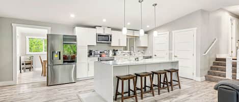 Modern kitchen with large island seating, stainless steel appliances