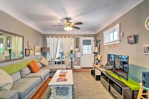 The living area features a comfortable sofa and Smart TV.