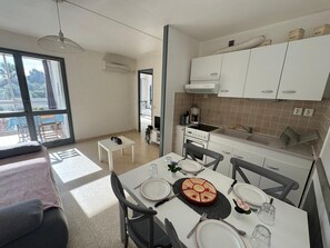 Fully equipped kitchen and dining room with all the necessary amenities: microwave, oven, refrigerator, hob, etc. This living space also includes a double sofa bed as well as a TV, providing a comfortable setting. It overlooks a closed loggia and the corridor.