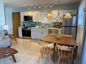 New kitchen dining area. Dishwasher, microwave, oven, frig. Wooden dining table.