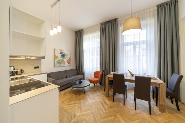 Living room with kitchenette, double sofa bed and large dining table