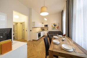 Living room with kitchenette, double sofa bed and large dining table