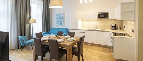 Living room with kitchenette, double sofa bed and large dining table