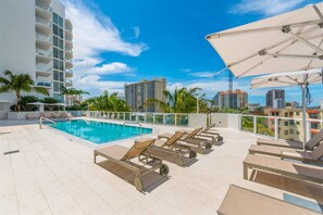 Rooftop pool w/ numerous chairs & sunbrellas